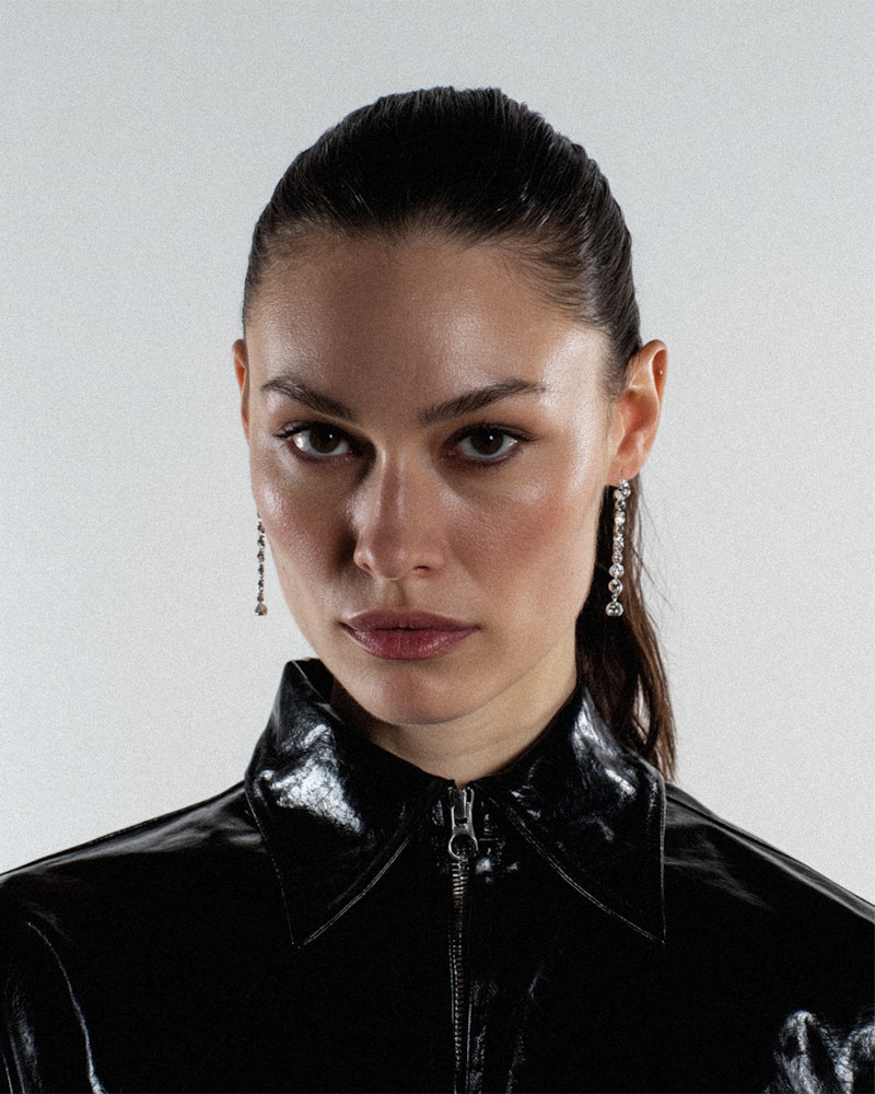 Model in a black patent leather jacket, slicked hair