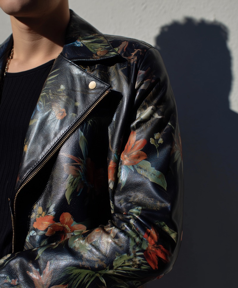 Detail of a floral-print leather biker jacket
